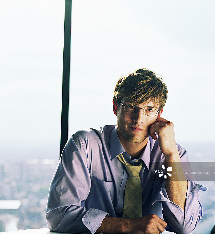 年轻商人手托脸的肖像图片素材