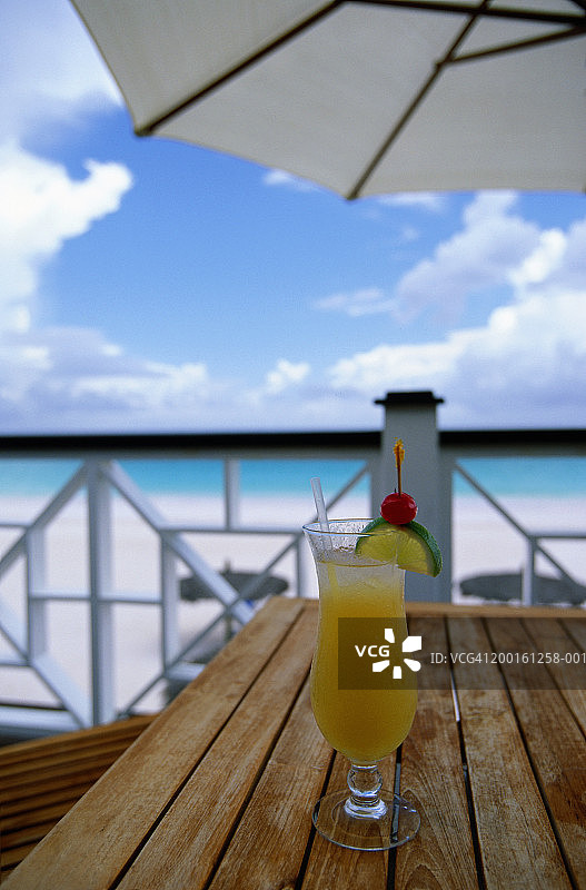 桌上的鸡尾酒，阳台俯瞰海滩图片素材