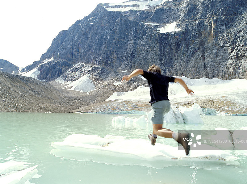 中年男人跳上冰块，后视图（模糊运动）图片素材
