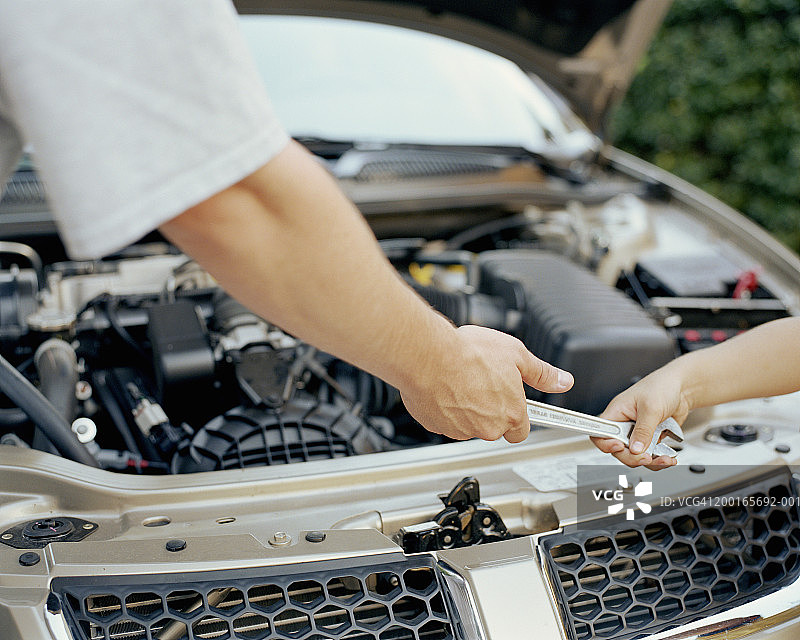 特写：父亲递扳手给儿子图片素材