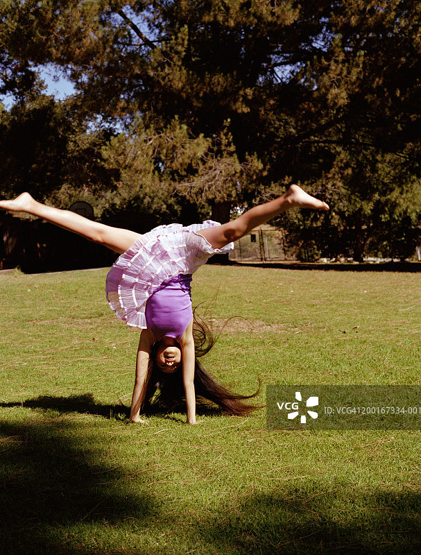 9-11岁女孩在户外表演倒立图片素材