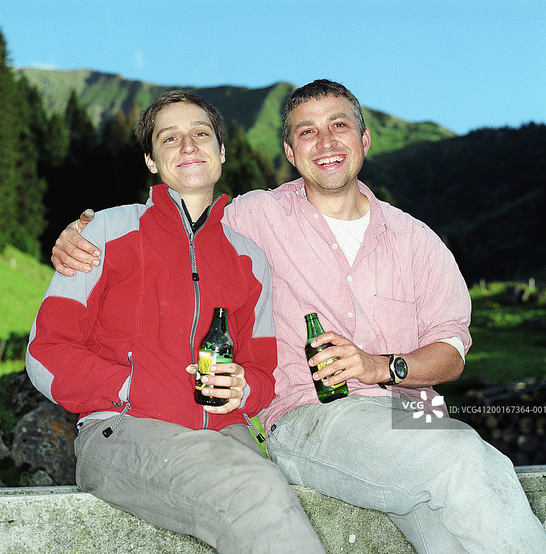 男人在户外拥抱女人，拿着饮料，微笑，肖像图片素材