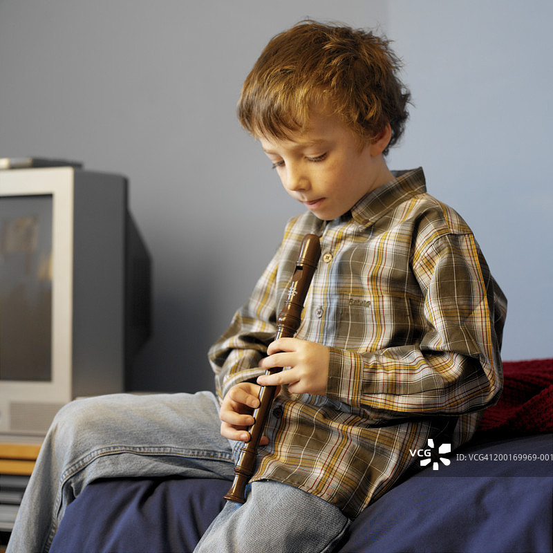 男孩（4-6岁）正在研究录音机的孔，中段图片素材