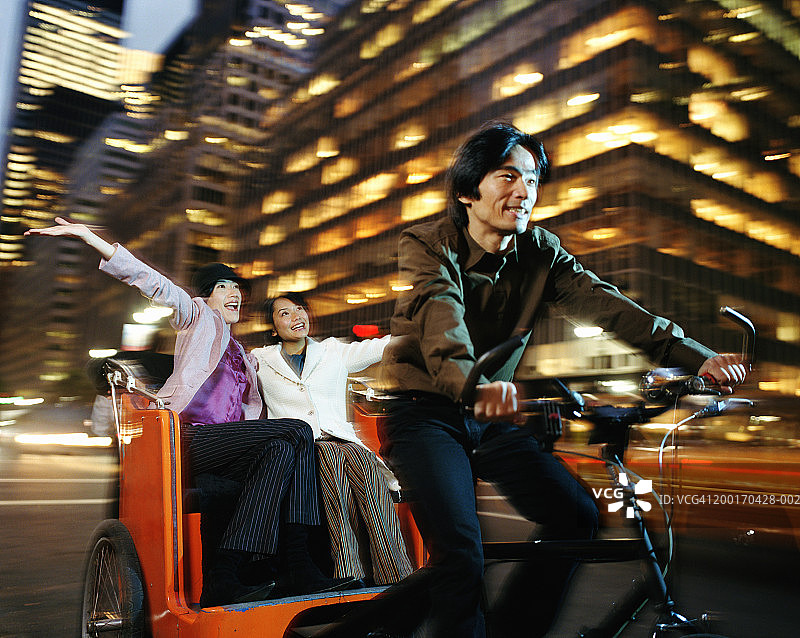 男人用三轮车带着两个女人，面带微笑（动态模糊）图片素材