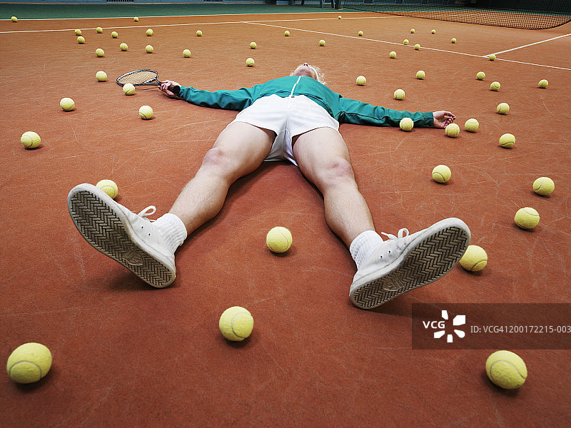男网球运动员躺在球中图片素材