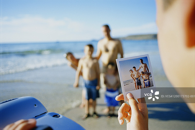 男孩(7-9岁)在海滩上与家人合影图片素材