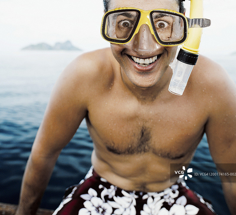 戴着呼吸管坐在船上微笑的男人特写图片素材