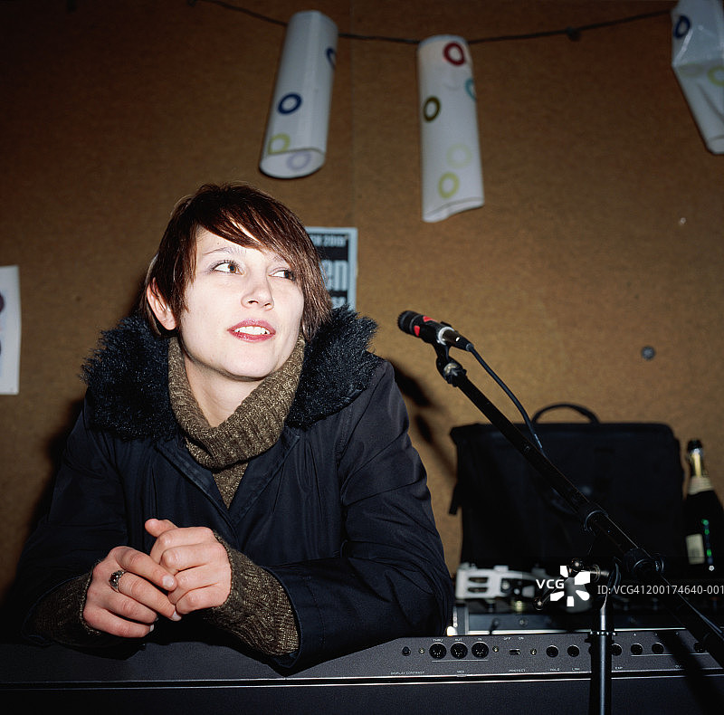 靠在键盘上，看向远方的年轻女人图片素材