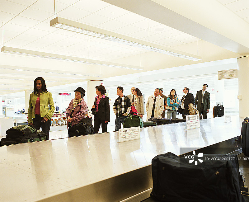 旅客在机场行李传送带旁等候图片素材