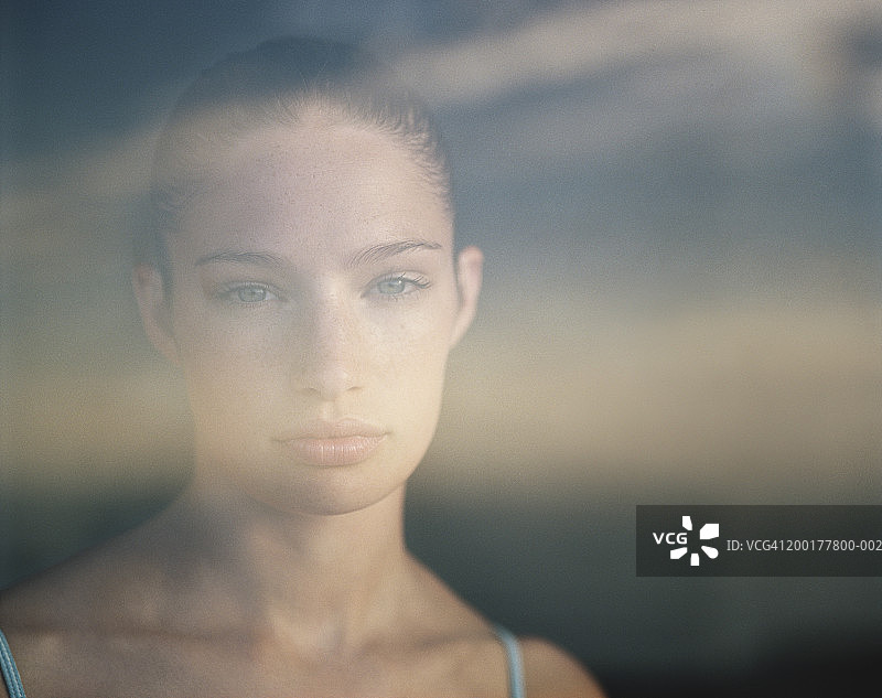 透过玻璃看到的年轻女人肖像图片素材