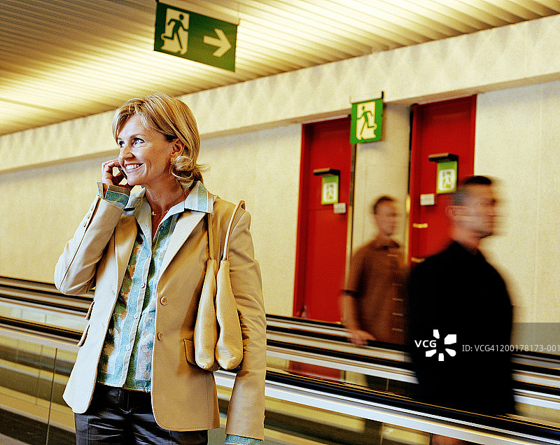 自动人行道上的商人，焦点在一名女性身上图片素材