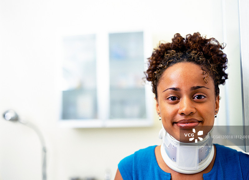 戴颈托微笑的年轻女人肖像图片素材