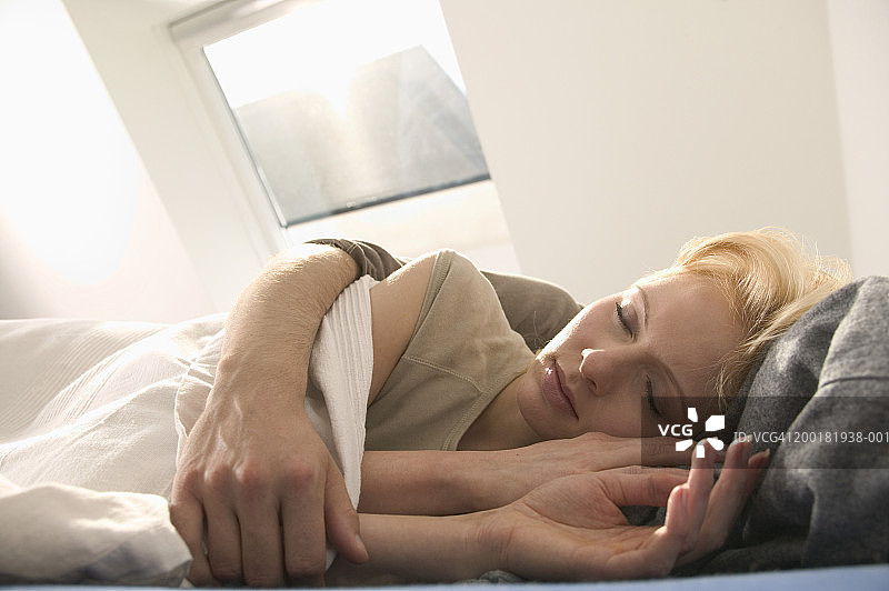 男人在床上拥抱闭着眼睛的年轻女人，特写图片素材