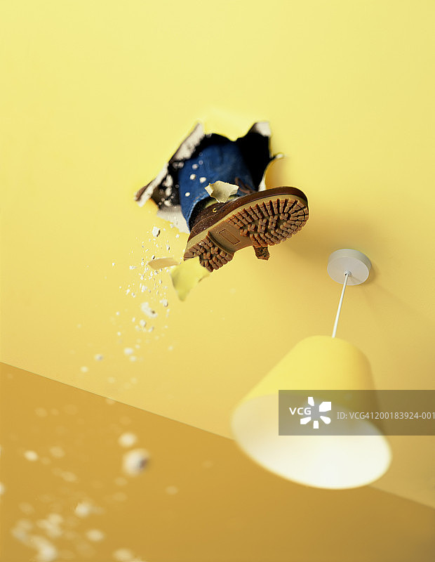 男人一脚踢穿天花板，低角度视角图片素材