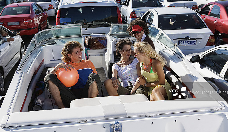 人们坐在交通拥堵中拖车上的船里图片素材