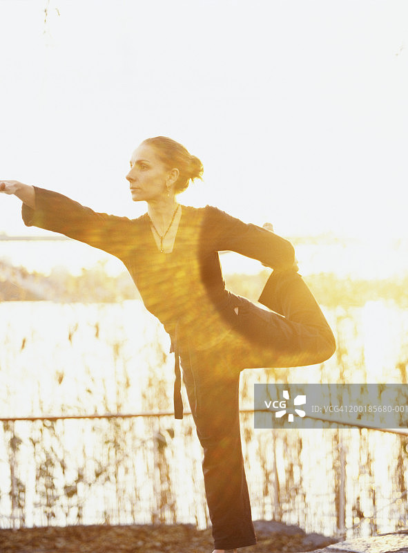 女人在户外水边表演舞者瑜伽姿势图片素材