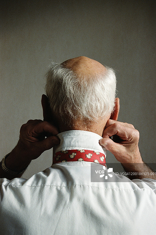 年长的男人整理领带，特写后视图图片素材