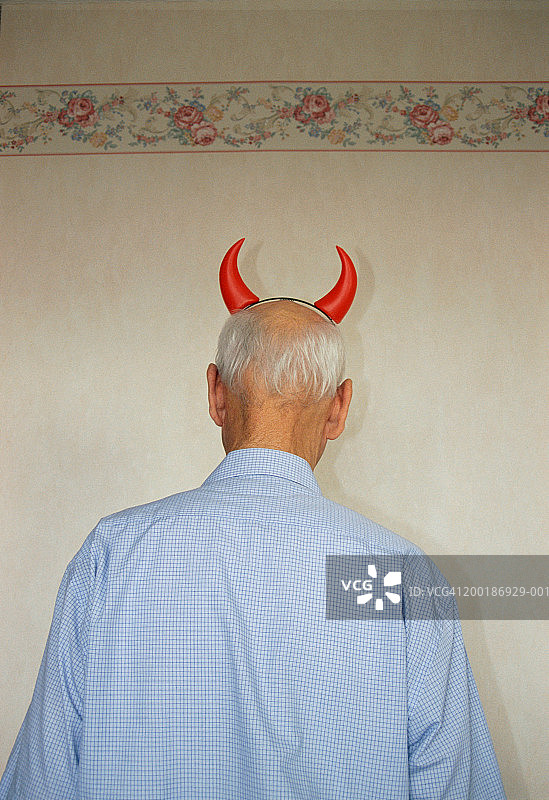 戴着恶魔角的年长男人，后视图图片素材