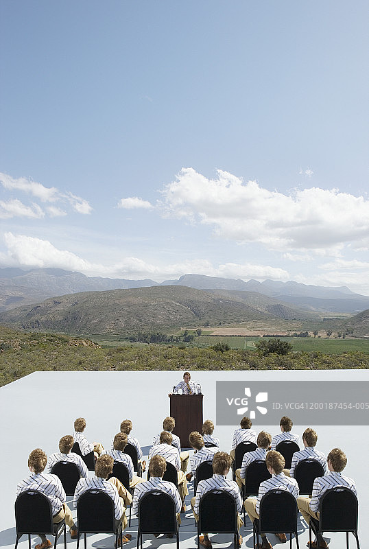 坐在演讲台前的男人（数字合成）图片素材