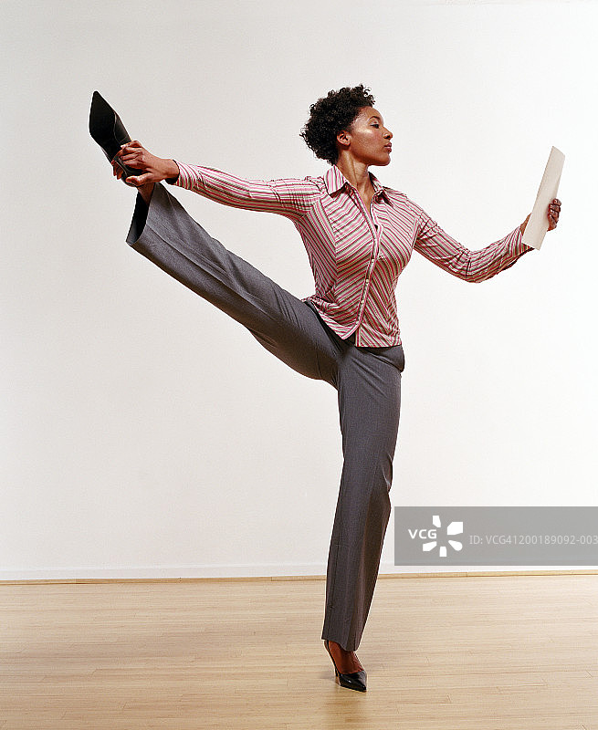 单腿站立查看文件的商务女人像图片素材