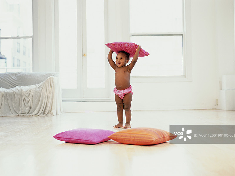 头顶枕头微笑的女孩（1-3岁）图片素材