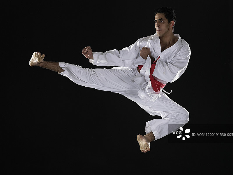 年轻男人练习武术，空中跳跃图片素材