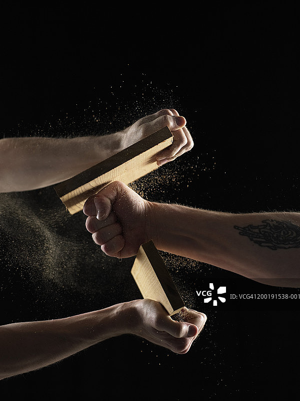 两个男人，一个拿着木板，一个用拳头击碎木板，特写图片素材