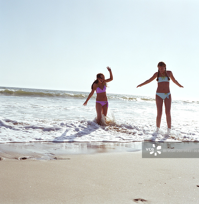两个年轻女子在海滩上冲浪图片素材