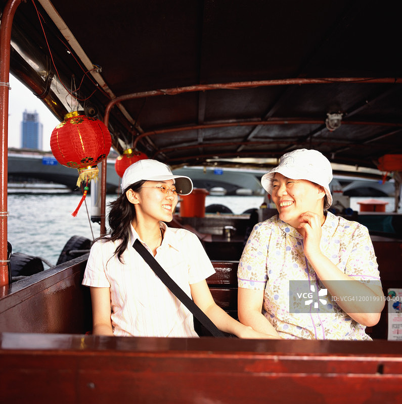 中年妇女和年轻女子在乘船游览，欢笑图片素材