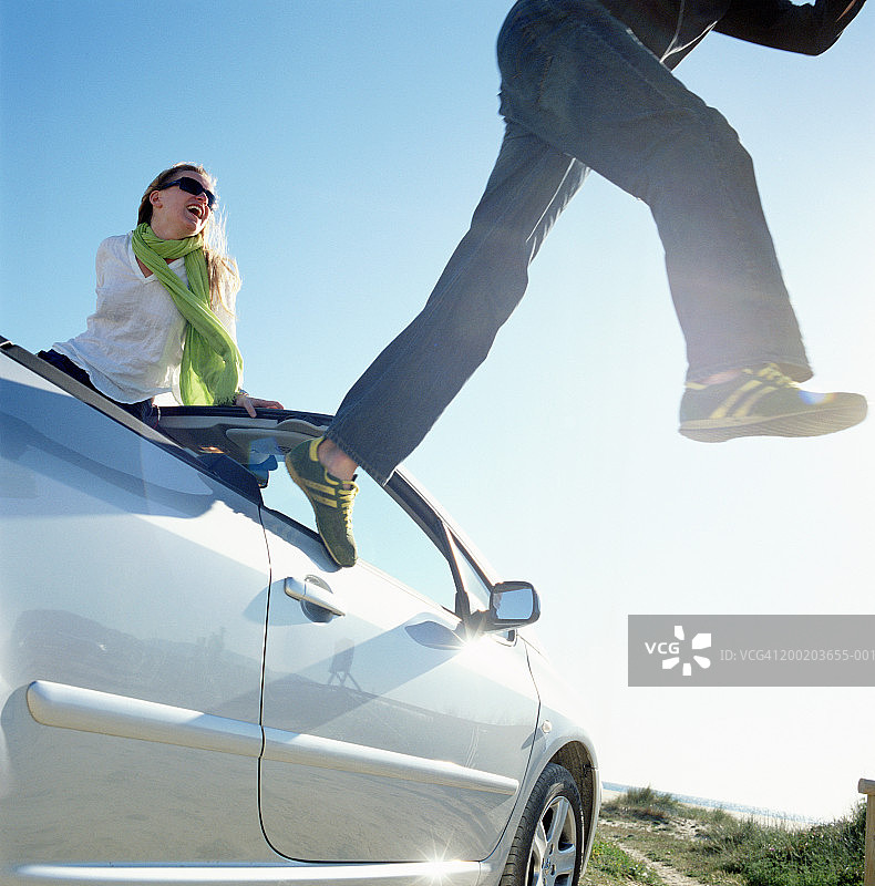 女人坐在车里，看着男人跳下车图片素材