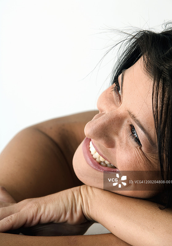 女人微笑着，看向别处，特写图片素材