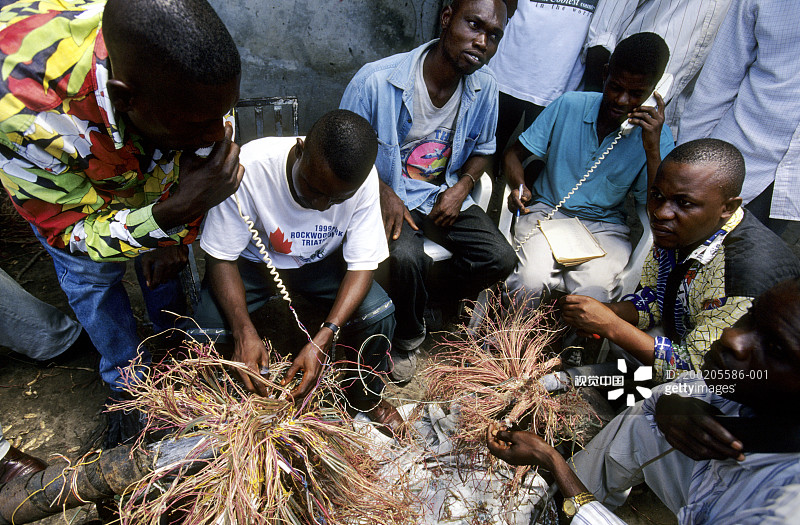 刚果工人在街上修理损坏的电话线图片素材