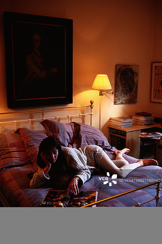 女人躺在床上看书图片素材