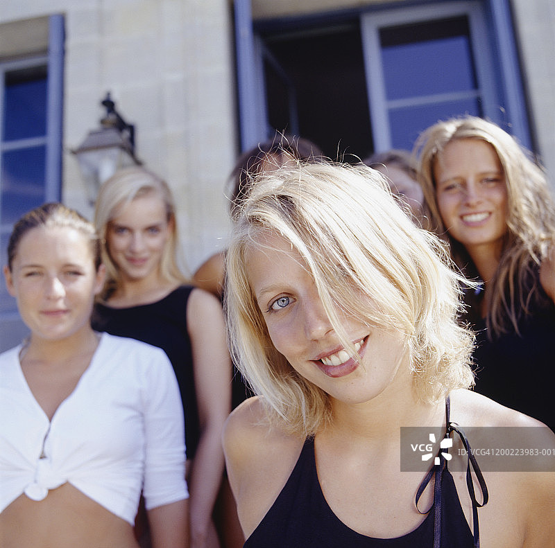 一群年轻女性站在房子前合影图片素材