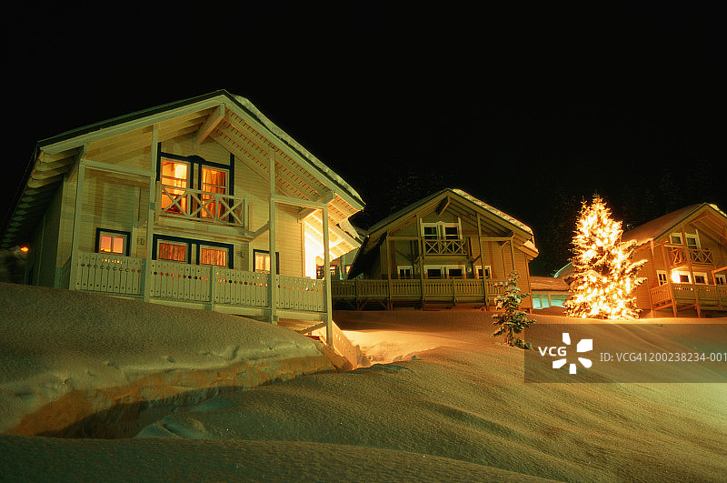 雪地里亮着圣诞灯饰的房屋图片素材