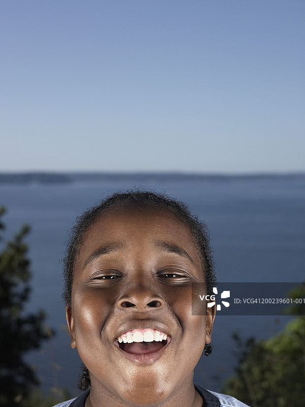 男孩（10-12岁）微笑，背景是海，肖像（专注于男孩）图片素材