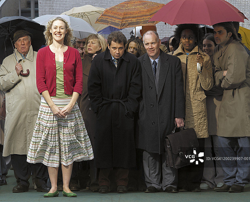 年轻女人站在人群前微笑，肖像图片素材