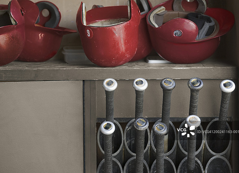 棒球休息区中的击球头盔和球棒图片素材