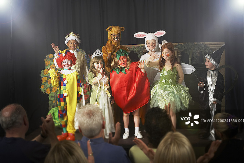 一群穿着戏服在舞台上挥手的儿童（11-14岁）图片素材