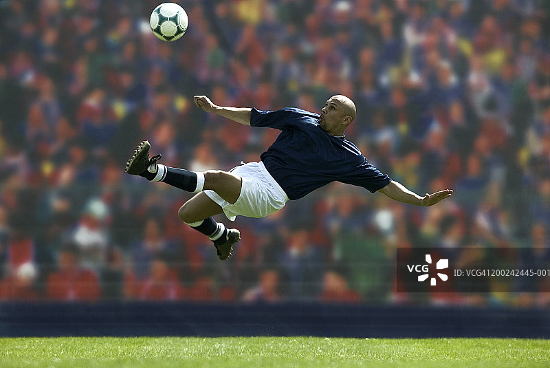 男性足球运动员在空中踢球图片素材