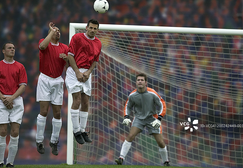 橄榄球运动员在球场上，一人正在顶球图片素材