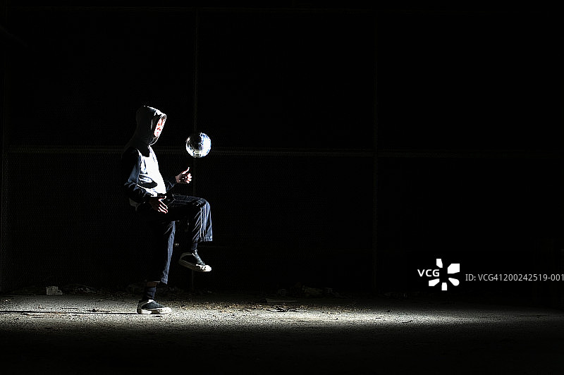 男人练习踢足球，侧面视角图片素材