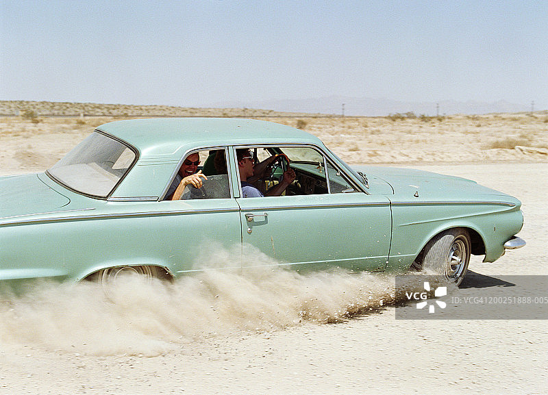 在土路上驾车的年轻男人图片素材