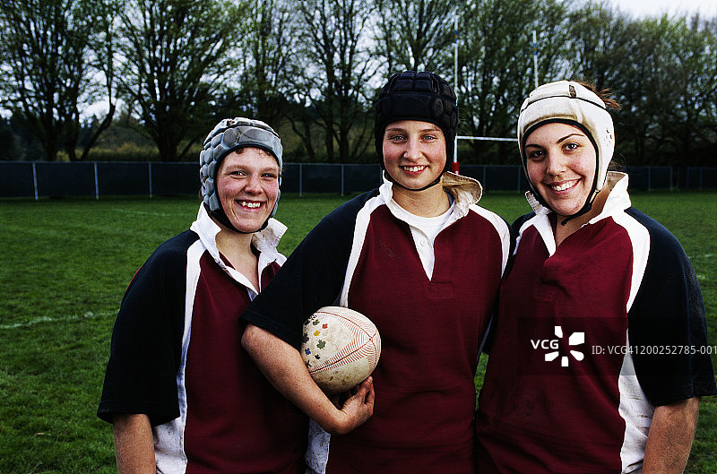 三个年轻女子橄榄球运动员的微笑肖像图片素材