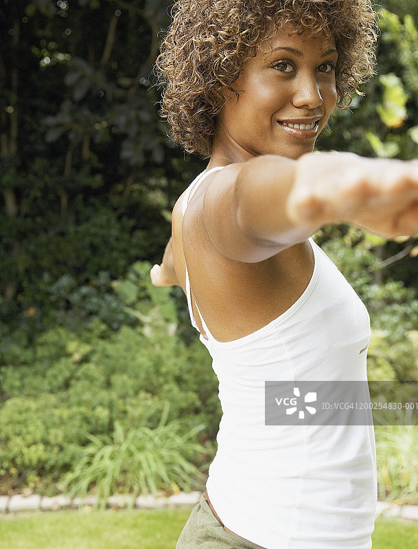 站在花园里伸开双臂微笑的女人图片素材