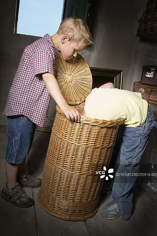 男孩和女孩（4-6岁）正在看藤条篮子里面图片素材