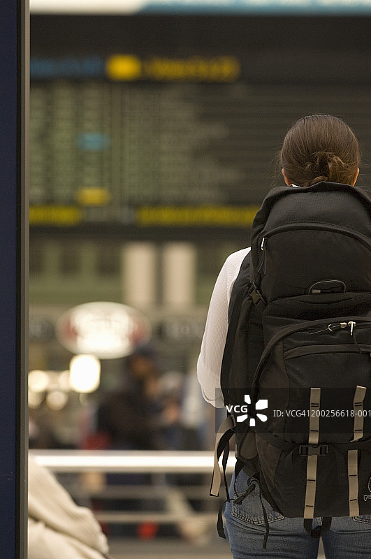 年轻女子在火车站背着背包，后视图图片素材