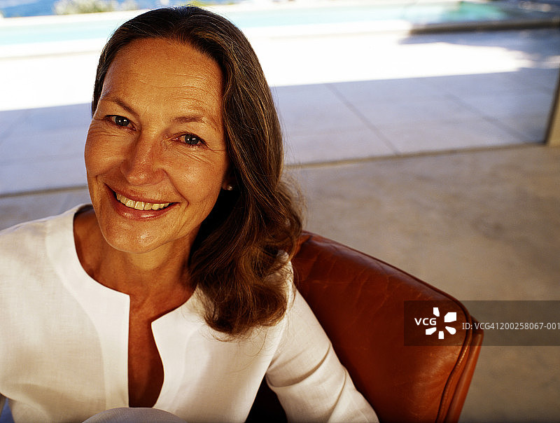 坐在椅子上微笑的中年妇女特写肖像图片素材