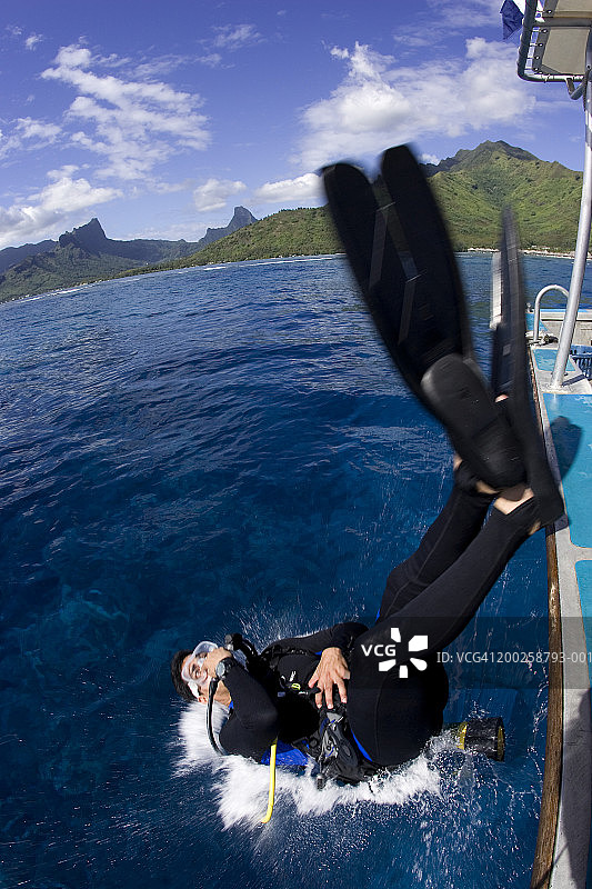 从潜水船上向后滚入水中的男性潜水员（模糊运动）图片素材