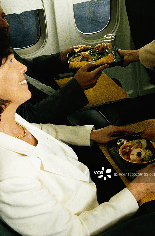 空乘在飞机上为商务人士服务图片素材